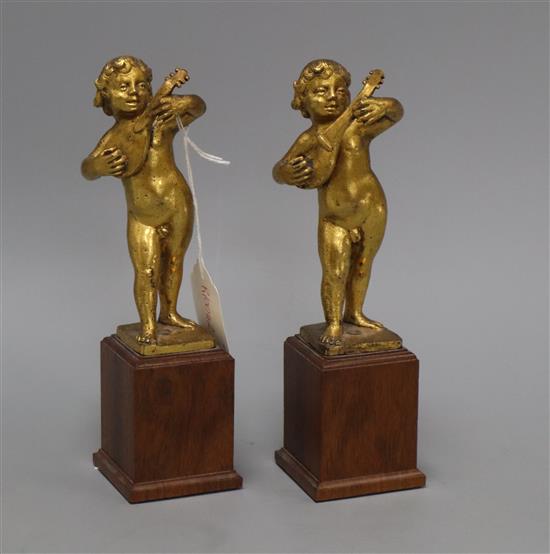 A pair of 17th century Italian gilt metal figures of putto playing mandolins, overall height 7.75in.
